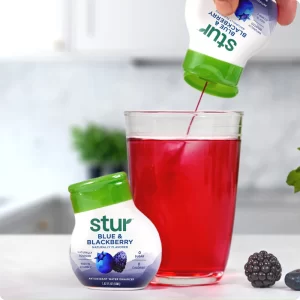 Stur drink being poured in glass of warer