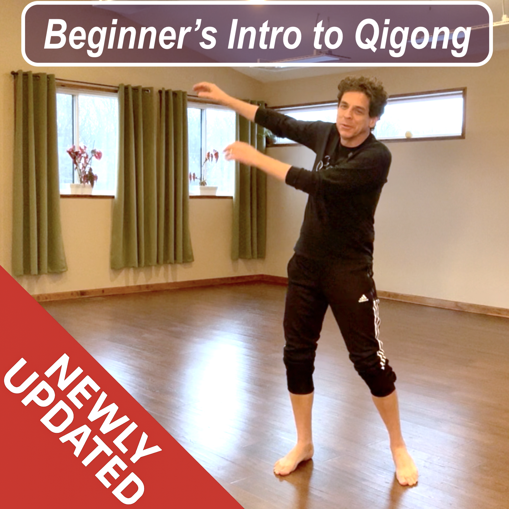 Joe Moody (aka Joe Drummer Boy) demonstrating beginner Qigong arm movements in a calm studio space, welcoming new students to an updated introductory Qigong routine.
