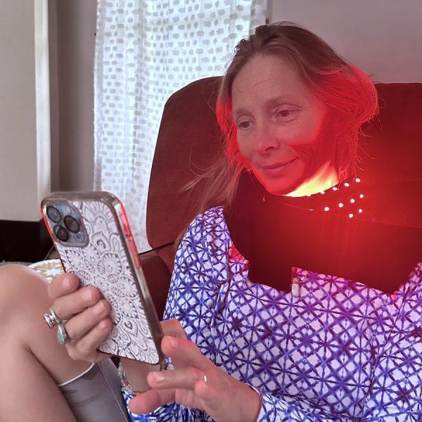 Melissa using the red light heating pad on her neck.