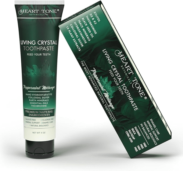 A 4 oz tube and matching box of Heart Tone Botanicals Living Crystal Toothpaste in Peppermint Mélange flavor. The dark green packaging features elegant leaf artwork and gold-white lettering. The label highlights ingredients such as nano hydroxyapatite, colloidal silver, earth minerals, essential oils, and theobromine, and notes it is fluoride-free, sulfate-free, and designed for enamel care and mineral support.