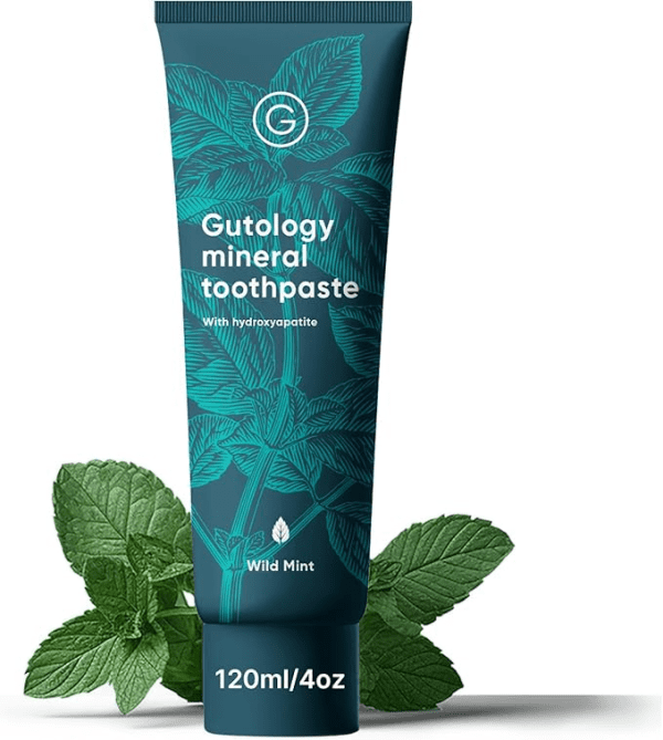 A 120 ml (4 oz) tube of Gutology Mineral Toothpaste in Wild Mint flavor, featuring teal botanical illustrations and minimalist white text that reads “Gutology mineral toothpaste with hydroxyapatite.” The tube is upright against fresh mint leaves, suggesting a natural, refreshing, fluoride-free formulation.